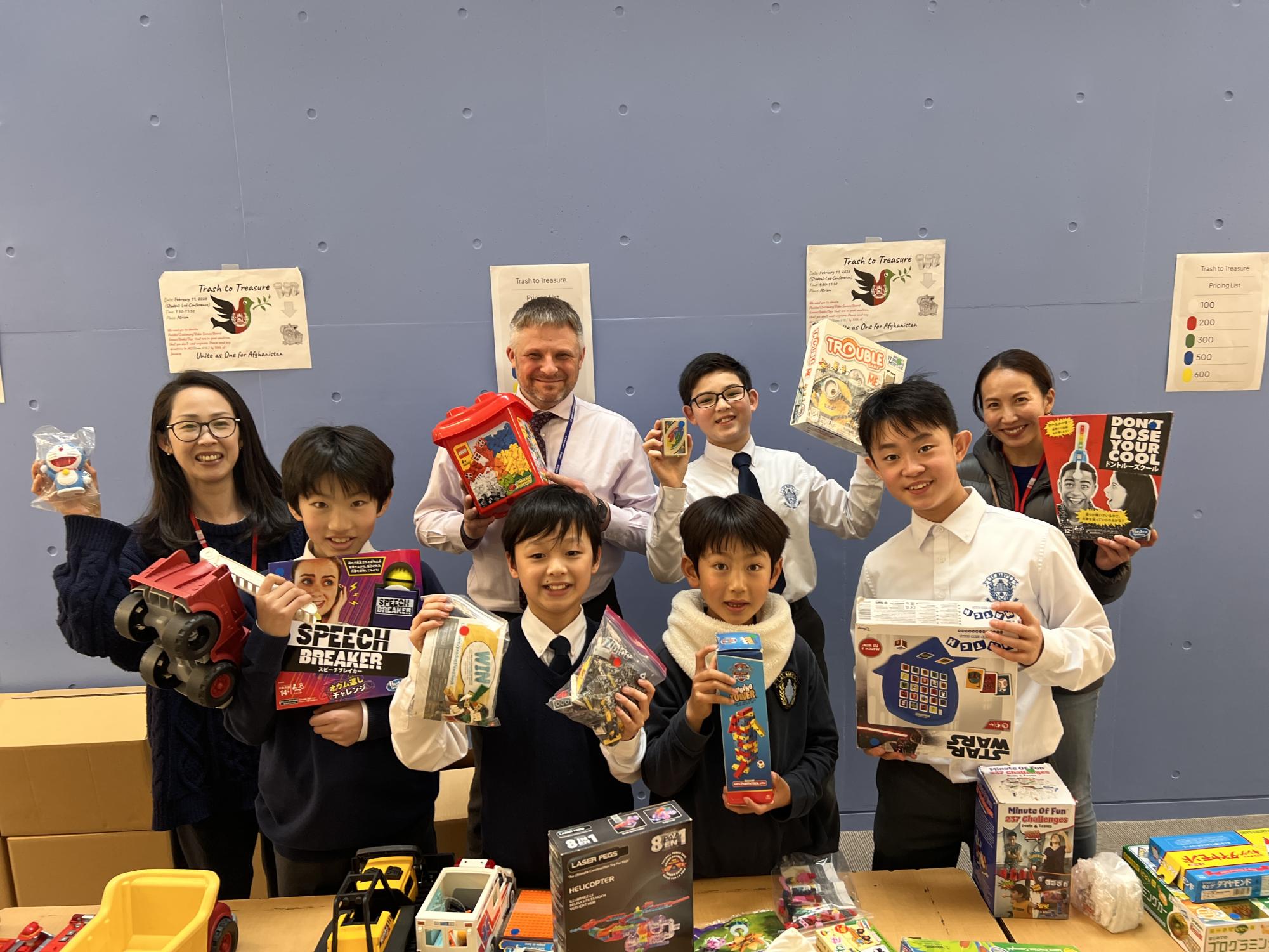 Kei and Koh alongside with classmates and parents on the day of the sale