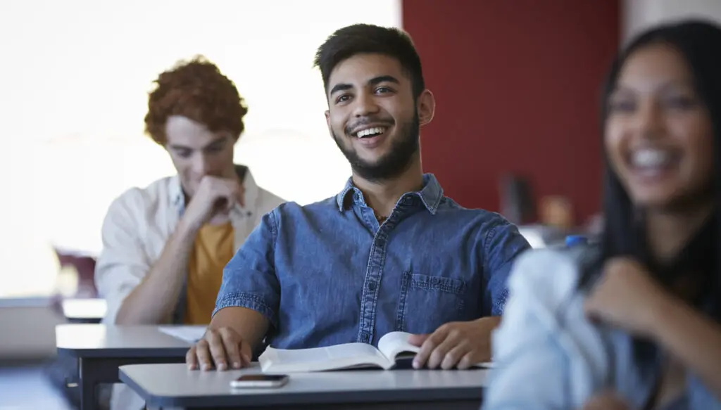 University students laughing during a lecture - Reuters